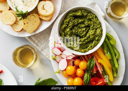 Vue de dessus des collations santé. Des légumes crus, croûtons de pain de sauce pesto et une sauce à l'ail sur fond de béton gris Banque D'Images