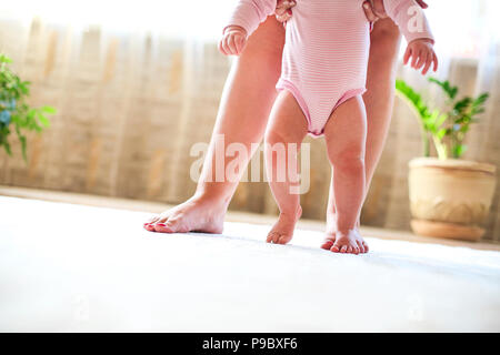 Mère et fille bébé marche close up. Premiers pas Banque D'Images