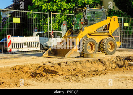 Drague orange sur les chantiers dans la ville. Construction d'égouts dans la région. Machines de travail en stationnement sur la route. Bulldozer sur place. Route abandonnée Banque D'Images