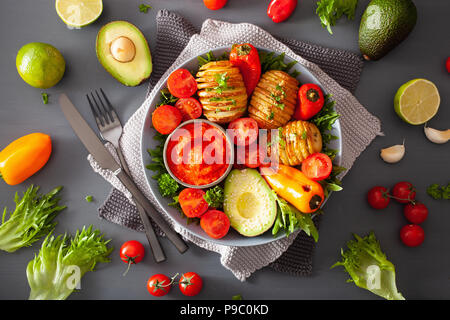 Bol bouddha vegan. dîner sain bol avec pommes de terre hasselback, avocat, tomate, poivrons et sauce au piment Banque D'Images