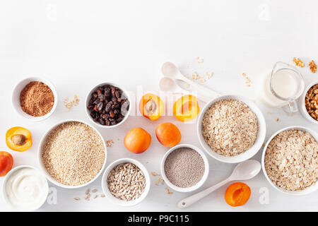 Variété de céréales brutes, les fruits et les écrous pour le petit-déjeuner. Flocons d'avoine et de l'acier coupé, l'orge, noyer, Chia, abricot. Des ingrédients santé Banque D'Images