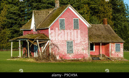 Ranch abandonné à vendre sur un terrain vert. Banque D'Images