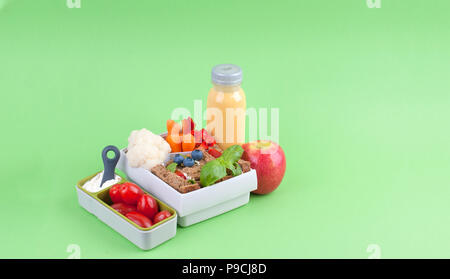Déjeuner dans un bureau fort et jus de fruit sur un fond vert. Espace libre pour le texte. Copy space Banque D'Images
