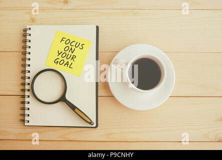 Se concentrer sur votre objectif du texte sur le bloc-notes avec loupe et tasse de café Banque D'Images