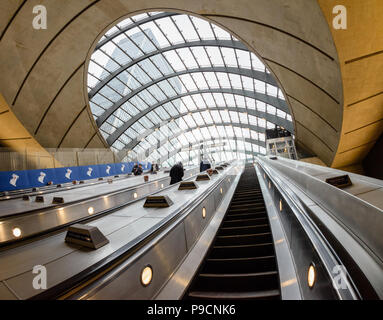 Vue grand angle des navetteurs voyageant le long des escaliers mécaniques à la station de métro de Canary Wharf à Londres Banque D'Images