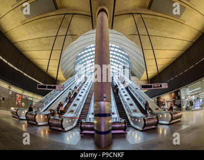 Vue grand angle des navetteurs voyageant le long des escaliers mécaniques à la station de métro de Canary Wharf à Londres Banque D'Images