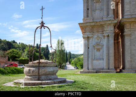 Un ancien puits avec - dans l'arrière-plan - la fin de la voie bordée de cyprès qui conduit de Montepulciano à l'église de San Biagio. Banque D'Images