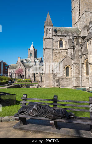 Sans-abri en bronze sculpture de Jésus sur un banc à l'extérieur de la cathédrale Christ Church, Dublin, Irlande, Europe Banque D'Images