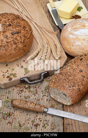 Pains et épépinées une miche de pain blanc sur une carte avec du blé et un couteau à pain. UK Banque D'Images