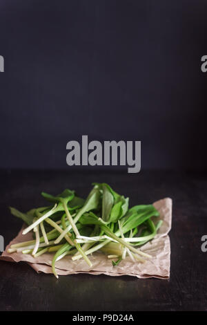 Ramson frais ail sauvage, choux vert dans un sac de jute sur un fond de bois foncé, selective focus Banque D'Images