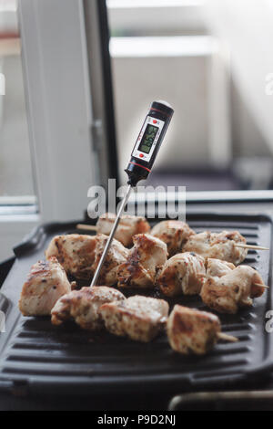 Boeuf-porc shish kebab préparé sur un gril électrique.Thermomètre pour déterminer l'état de préparation de la viande et de la température Banque D'Images