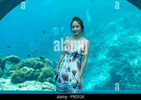 Belle femme asiatique dîner le monde sous-marin, sous-marin de fond restaurants dans les Maldives. Banque D'Images