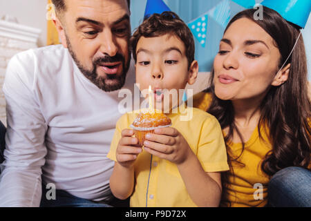 Happy boy blowing out candle Banque D'Images