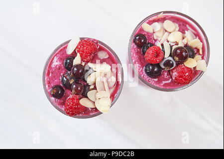 Deux verres de smoothies aux fruits rose smoothie ou milk-shake ou un cocktail sur fond de bois blanc. Régime alimentaire sain juteux vitamine boire ou végétalien raw food concept Banque D'Images