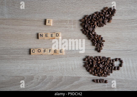 J'ai besoin d'une quotation word avec les grains de café torréfiés placée sous la forme d'une tasse et l'icône de fumée sur fond de bois Banque D'Images