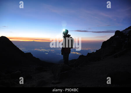 Silhouette d'alpiniste debout sur une montagne en face de l'horizon avec le volcan Iztaccihuatl Montage lampe frontale, Mexique Banque D'Images