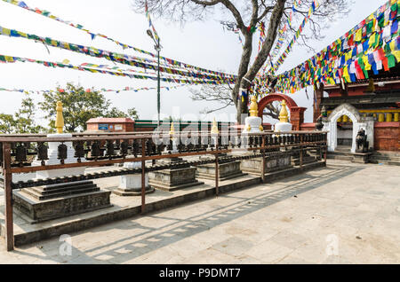 Sanctuaires bouddhistes tibétains, priant, roues et les drapeaux de prières dans Maha Manjushree Sarashwati Temple près de Swayambhunath, Katmandou, Népal Banque D'Images