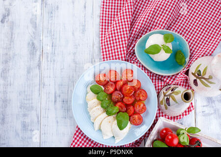 Salade caprese italien avec. Salade composée de légumes et de fromage. Vaisselle en céramique. Espace libre pour le texte. Sèche-serviettes dans une cage rouge Banque D'Images