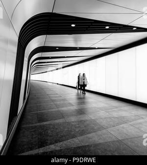 Deux femmes marchant dans le voyant allumé tunnel reliant St Pancras International et stations de King's Cross à Londres Banque D'Images