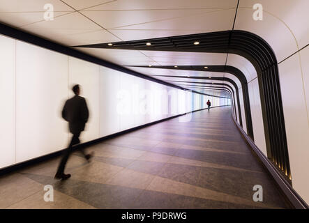 Deux personnes marchant dans le voyant allumé tunnel reliant St Pancras International et stations de King's Cross à Londres Banque D'Images