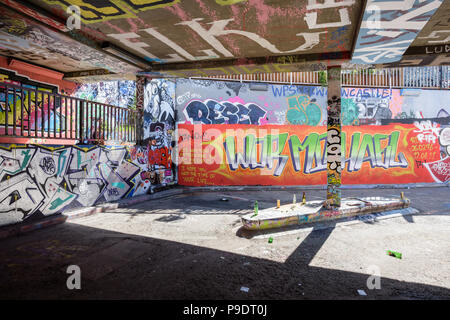 Des bouteilles vides et les canettes d'alcool à gauche dans Tunnel Banksy Leake Street à Waterloo, Londres, sur une toile de graffitis sur les murs Banque D'Images