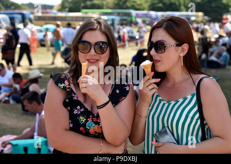 Deux sœurs Roumaines (28 & 29 ans) eating ice cream cones en été, pour un rallye bus, Alton, Hampshire, Royaume-Uni. Dimanche 15 juillet 2018. Banque D'Images