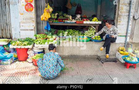 Deux femmes vietnamiens commerçants s'occuper de leur épicerie vendant des fruits et légumes à Ho Chi Minh City, Vietnam. Banque D'Images