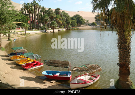 Bateaux colorés sur la rive de la lagune Huacachina oasis au village à Ica, Pérou, Amérique du Sud Banque D'Images