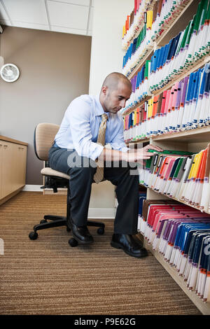 Un Middle Eastern woman chemises, cherche dans les documents d'information. Banque D'Images