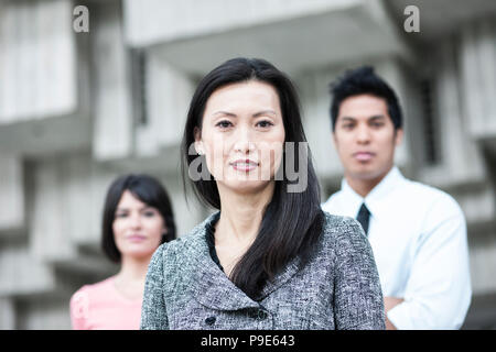Une équipe de course mixte d'hommes d'affaires avec une femme asiatique en tête. Banque D'Images