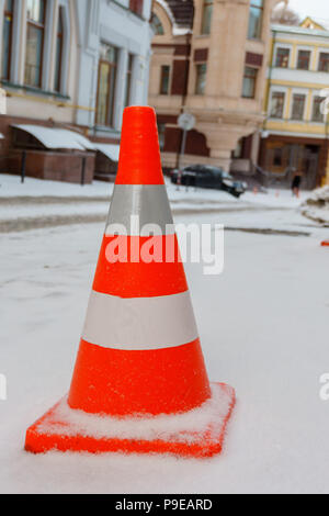 Orange et blanc de la route sur le cône réfléchissant snowy street close up Banque D'Images