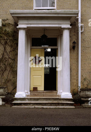 Porte jaune sur maison géorgienne avec piliers classiques Banque D'Images