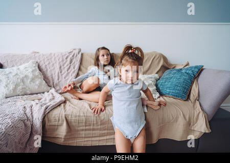 Deux petites filles dans une chambre sur le canapé Banque D'Images