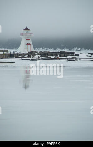 Lion's Head Harbour (Péninsule de Bruce, en Ontario) avec la fonte de la glace sur la baie reflétant et humide. Banque D'Images