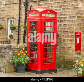 Une boîte de téléphone rouge K6 (UK) et wall postbox dans Esholt, West Yorkshire, Angleterre. Banque D'Images