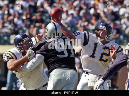 Oakland, Californie, USA. 5Th Oct, 1997. Oakland Raiders vs San Diego Chargers à Oakland Alameda County Coliseum Dimanche, 5 octobre 1997. Battre les chargeurs Raiders 25-10. San Diego Chargers quarterback Stan Humphries (12) passe au-dessus de la tête d'Oakland Raiders Chester McGlockton attaquer défensive Crédit : Al Golub/ZUMA/Alamy Fil Live News Banque D'Images