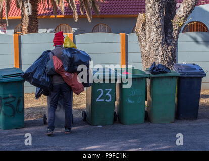 Johannesburg, Afrique du Sud - un homme au chômage recherche dans les poubelles résidentielles avec copie espace image au format paysage Banque D'Images