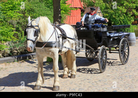 Un conducteur d'un chariot à cheval en prenant une petite pause entre deux ride en plein air musée de la ville Den Gamle By à Aarhus, Danemark Banque D'Images