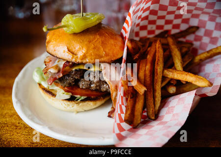 Burger au bacon, fromage et piment jalapeno et frites sur le côté. Banque D'Images