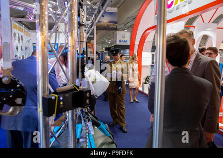 AirFarnborough Farnborough Airshow 2018, 17 juillet. show 2018 Journée du commerce. Un soldat regarde une brochure de l'un des stands à Farnborough. Banque D'Images