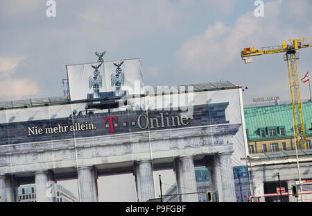 Allemagne, Berlin, Porte de Brandebourg avec sculpture Quadriga, déesse romaine Victoria est un cheval de chariot à amener la paix dans la ville, construit 1789-1793, enveloppée pendant des travaux de rénovation en 2001 avec l'annonce de l'entreprise de télécommunication allemand en ligne T Banque D'Images