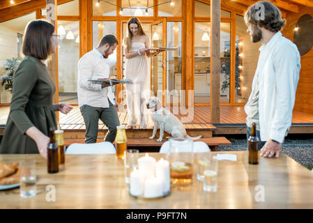 Les amis de la préparation pour le dîner près de la chambre Banque D'Images