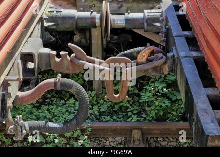 Les accouplements sur rusty old vintage des véhicules ferroviaires ou des wagons sur une ligne de chemin de fer désaffectées ou envahi par la voie Banque D'Images