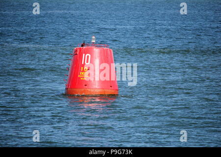 Bouée balise rouge avec limite de vitesse de 10 noeuds, flottant dans la mer ou l'océan bleu Banque D'Images