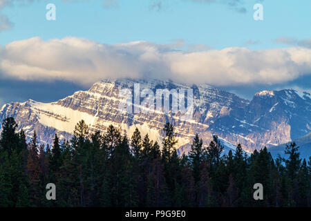 Près du Mont Edith Cavell, dans le Parc National Jasper avec l'éclat du soleil du matin et les nuages bas en ordre décroissant sur le sommet. Banque D'Images