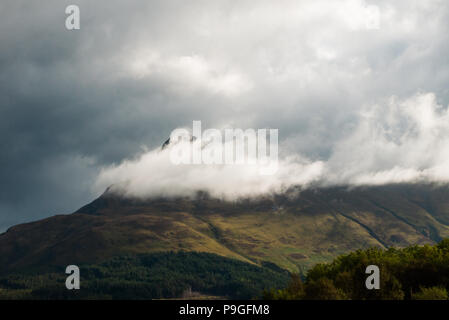 Whispy cloud couvre partiellement le Pap of Glencoe vus de Ballachulish, en Écosse. Banque D'Images