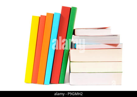 Petit tas et leaning rangée de livres colorés isolated on white Banque D'Images