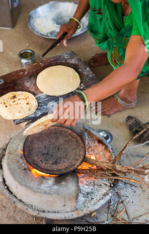 Une femme porte sur un open chapatis au feu de bois leur maison à Ahmedabad, Inde. Banque D'Images