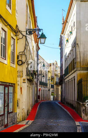 Vide coloré étroite rue pavée de la ville portugaise de Santarem dans la région de Ribatejo avec tapis rouge bordé de trottoir, trottoir Banque D'Images