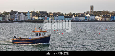 Un petit bateau de pêche au homard Donaghadee Harbour, l'Irlande du Nord, avec la ville et l'église. Banque D'Images